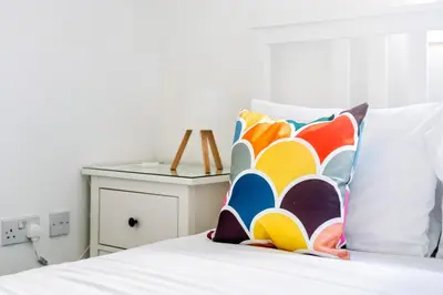 a bed with two colorful pillows on top of it at Argyle Street Apartments in Glasgow