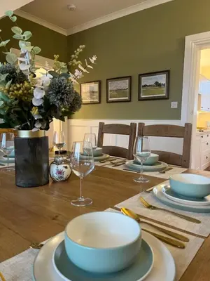 a dining room table with plates and wine glasses at The Troon Hoose in Troon