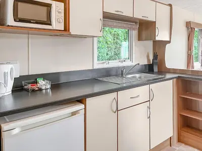 a kitchen with white cabinets and a sink at Platinum in Newton Stewart
