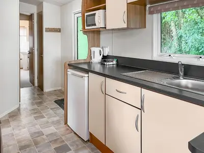 a kitchen with white cabinets and a sink and a window at Platinum in Newton Stewart