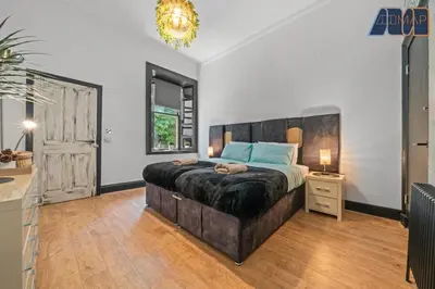 a bedroom with a large bed with a dog laying on it at Modern 2 Bed Sleep 4 In Gourock in Gourock