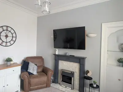 a living room with a fireplace and a flat screen tv at Largs seaside retreat in Largs