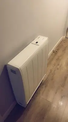 a white heater in a room with a wooden floor at Casa da Paz in Glasgow