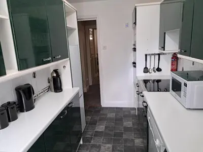 a kitchen with white counters and a microwave at Historic central apartment in Castlehill Mansions in Campbeltown
