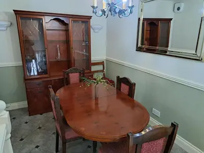 a dining room table with chairs and a mirror at Historic central apartment in Castlehill Mansions in Campbeltown