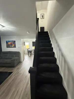 a staircase in a house with a living room and a couch at Home Comfort Prestwick in Prestwick