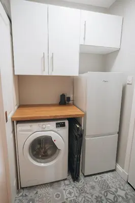 a washer and dryer in a kitchen with white cabinets at Anchors Retreat in Ayr