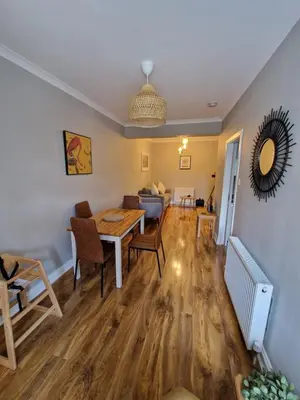 a dining room and living room with a table and chairs at Anchors Retreat in Ayr