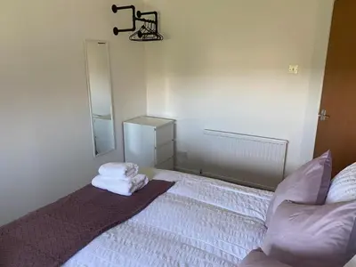 a bedroom with a bed with towels on it at Glen Cannich - Top Location, 2BR Accessible apt in Inverkeithing
