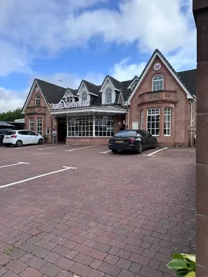 a building with a car parked in a parking lot at The Villa Hamilton in Hamilton
