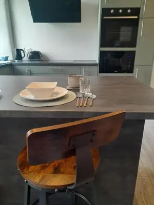 a kitchen with a wooden chair at a kitchen counter at Outlander 4 Apartment Doune in Stirling