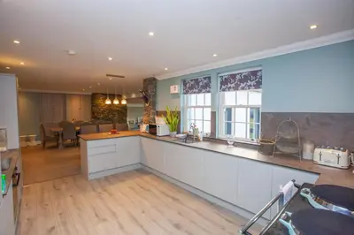 a kitchen with white cabinets and a counter top at 5 Bed Family Home Lochwinnoch in Lochwinnoch