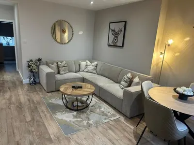 a living room with a couch and a table at BOFA Snug Apartment in Bridge of Allan