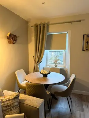 a living room with a table and chairs at BOFA Snug Apartment in Bridge of Allan
