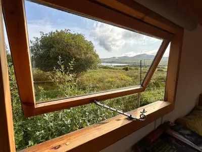 a window in a room with a view of a field at The Shepherd's Hut in Craighouse