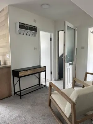 a living room with a bed and a table at Upper Mill Apartment in Newmilns