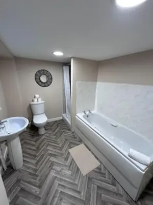 a bathroom with a tub and a toilet and a sink at Abbeygreen Village House in Lesmahagow