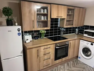 a kitchen with wooden cabinets and a white refrigerator at Abbeygreen Village House in Lesmahagow