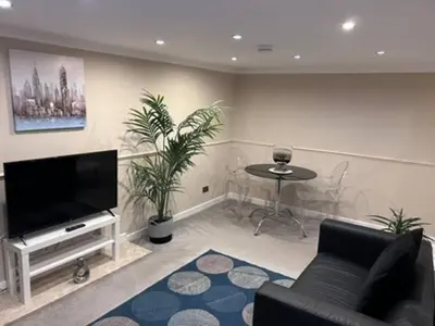 a living room with a couch and a tv and a table at Abbeygreen Village House in Lesmahagow