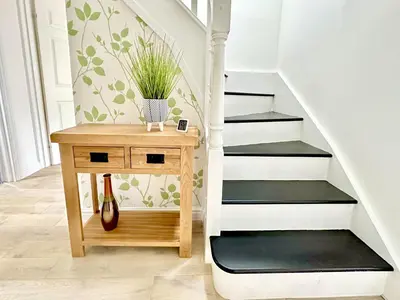 a small table with a plant on it next to a staircase at Barrmor View in Kilmartin