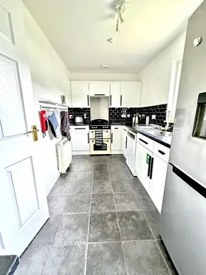 a kitchen with white cabinets and a tile floor at Barrmor View in Kilmartin