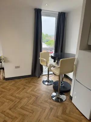 a room with a table and chairs and a window at Stylish Flat in City Center in Moffat