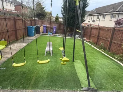 a backyard with four swings on the grass at Glasgow 3 bed Guest House in Glasgow