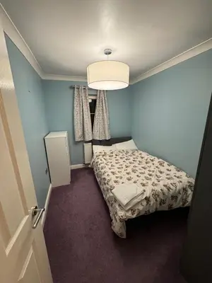 a small bedroom with a bed and a light at Glasgow 3 bed Guest House in Glasgow