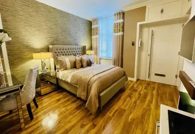 a bedroom with a bed and a table and a desk at Isle Be Back-Ground Floor Flat in Millport