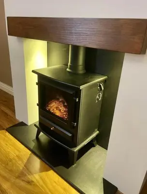 a black stove sitting in the corner of a room at Isle Be Back-Ground Floor Flat in Millport
