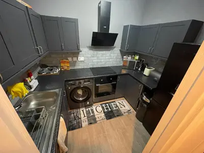 a kitchen with a sink and a washing machine at Fountain park get away one bedroom in a 2 bedroom apartment in Edinburgh