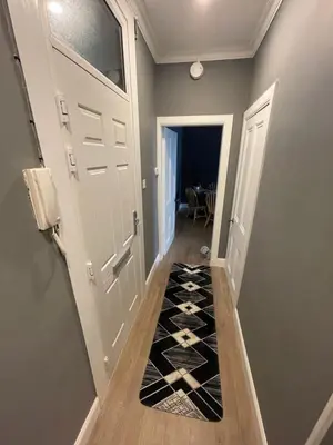 a hallway with a door and a black and white tile floor at Fountain park get away one bedroom in a 2 bedroom apartment in Edinburgh