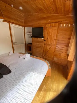 a bedroom with a bed and a flat screen tv at Rowardennan Rooms in the lodge Lodge no 2 in Rowardennan