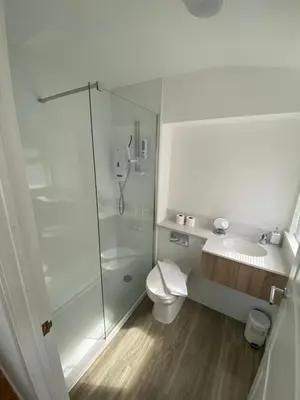 a bathroom with a shower and a toilet and a sink at Rowardennan Rooms in the lodge Lodge no 2 in Rowardennan