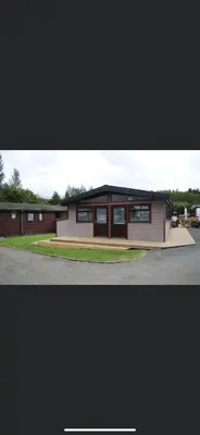 a building with a lot of windows in a parking lot at Rowardennan Rooms in the lodge Lodge no 2 in Rowardennan