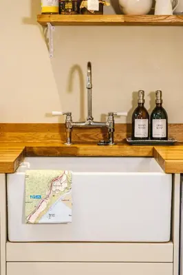 a sink in a kitchen with two bottles of wine at Craigendarroch No 2 in Acharn