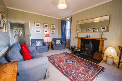 a living room with blue couches and a fireplace at Craigendarroch No 2 in Acharn