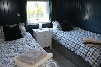 two twin beds in a room with a window at Fortingall Cottage - Dalmally in Dalmally