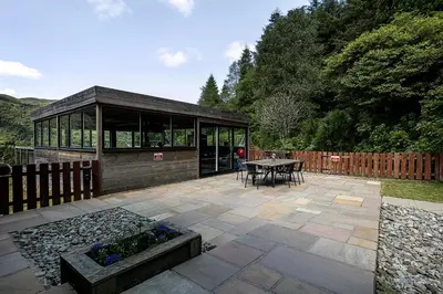a pavilion with a table and a bench in a garden at Dalnahua on 'The Secret Coast'