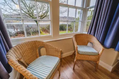 two wicker chairs sitting in a room with windows at Castle Cottage No 2 in Acharn