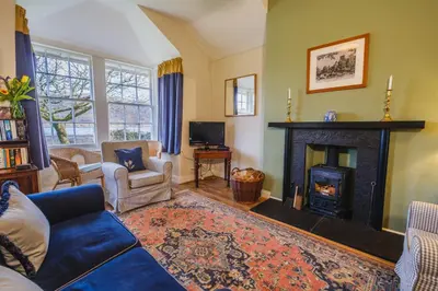 a living room with a couch and a fireplace at Castle Cottage No 2 in Acharn