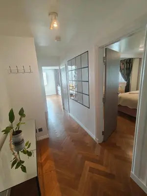 a living room with a hard wood floor and a bedroom at Modern Ground Level Flat in Clydebank