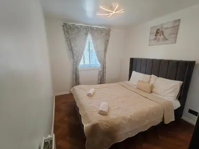 a bedroom with a bed with two towels on it at Modern Ground Level Flat in Clydebank