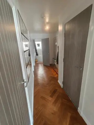 a hallway of a house with a wooden floor at Modern Ground Level Flat in Clydebank