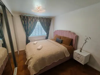a small bedroom with a bed and a window at Modern Ground Level Flat in Clydebank