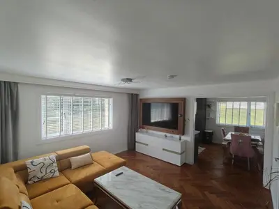 a living room with a couch and a flat screen tv at Modern Ground Level Flat in Clydebank