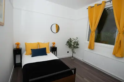 a bedroom with a bed with yellow curtains and a window at Private Home North of Dunblane in Braco
