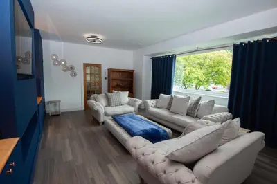 a living room with white furniture and a large window at Private Home North of Dunblane in Braco