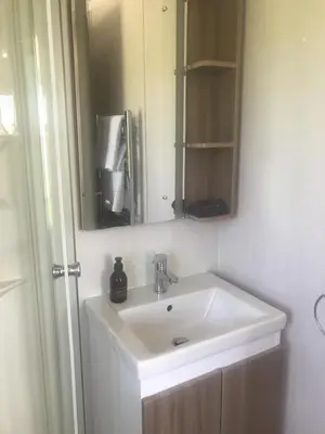 a bathroom with a white sink and a mirror at Cnocanreoch Farm Glamping in Kilmory