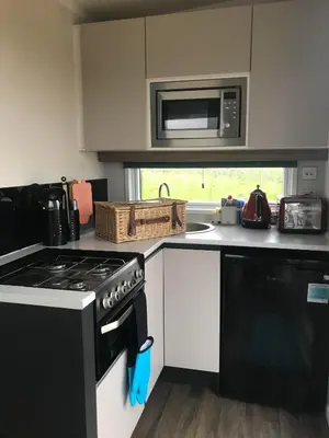 a kitchen with a stove and a microwave at Cnocanreoch Farm Glamping in Kilmory